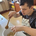 Uczeń kruszy drewnianą łyżką ciasteczka