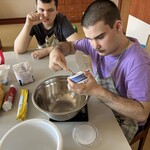 Uczeń wkłada łyżką do miski serek mascarpone