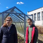 Uczeń z uczennicą stoi przed szklarnią