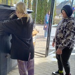 Uczennica wrzuca worek z zebranymi śmieciami do śmietnika