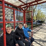 Uczniowie siedzą na przystanku