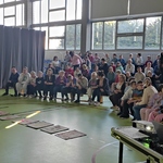 Organizatorki gry mówią do zebranej na sali społeczności szkolnej