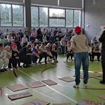 Organizatorki gry mówią do zebranej na sali społeczności szkolnej