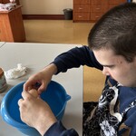 Uczeń wbija jajko do miski