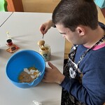 Uczeń wkłada masło orzechowe do miski