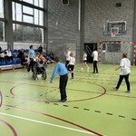 Uczniowie na sali gimnastycznej wykonują ćwiczenia z obręczami