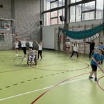 Uczniowie na sali gimnastycznej wykonują ćwiczenia z obręczami