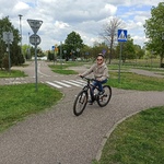 Uczennica jedzie rowerem po ścieżce w miasteczku rowerowym,