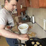 Uczeń smaży placuszki, nakłada łyżką masę na patelnię