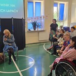 Uczniowie, właścicielka psa przewodnika i pies podczas apelu.