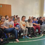 Uczniowie siedzą podczas apelu.