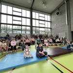 Społeczność szkolna zgromadzona na sali gimnastycznej uczestnicząca a imprezie