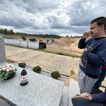 Uczniowie i nauczyciel przy grobie