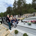 Uczniowie i nauczyciel przy grobie