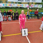 Uczennica z medalem stoi za tabliczką z numerem 1