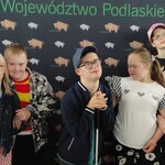 grupa uczniów na tle plakatu
