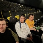 Uczniowie siedzą na sali kinowej