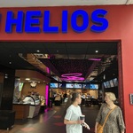 Nauczycielka i uczennica przed wejściem do kina, nad nimi napis „Helios”