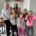 Pani dyrektor, nauczycielka i grupa uczniów z medalami