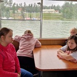 Uczniowie siedzą przy stoliku na statku