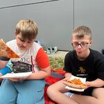 Uczniowie jedzą pizzę