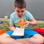 Uczeń je pizzę