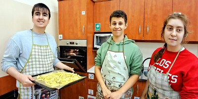 Uczniowie w fartuszkach z przygotowanymi frytkami