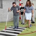 Uczeń i nauczycielka przechodzą przez przejście dla pieszych
