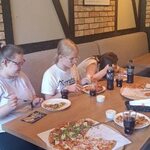 Uczennice w pizzerni jedzą pizzę