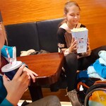 Uczniowie siedzą przy stole z popcornem i napojami