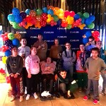 Uczniowie stoją przed ścianką z balonami