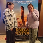 Uczennice na tle plakatu w kinie