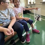 Uczennica trzyma torebkę z piórkami puchacza