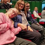 Nauczycielka I uczniowie siedzą na sali koncertowej.