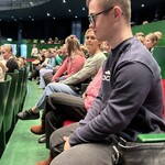 Uczniowie siedzą na sali w operze, czekają na koncert