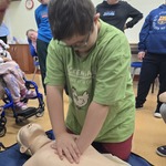 Uczeń wykonuje masaż serca na fantomie
