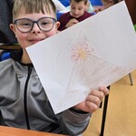 Uczeń pokazuje narysowany na kartce wulkan