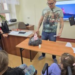 Uczennica na wózkach i prowadzący warsztaty patrzą na wulkan stojący na stoliku