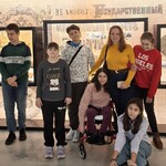 Nauczycielka i uczniowie na tle wystawy muzealnej