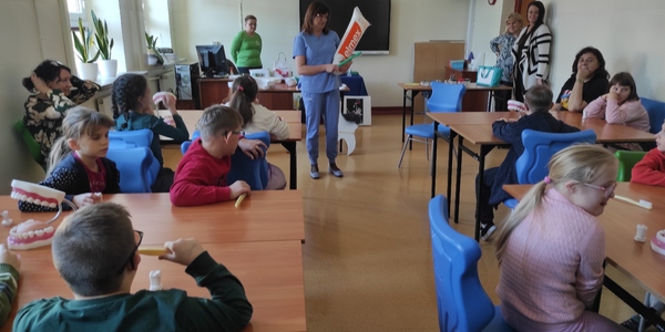 Uczestnicy warsztatów siedzą przy stołach