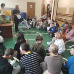 Uczniowie siedzą na podłodze i obserwują nauczycielki prowadzące warsztaty