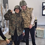 Uczniowie w mundurach wojskowych i kaskach na głowie