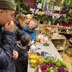 Grupa uczniów stoi przy ladzie w kwiaciarni