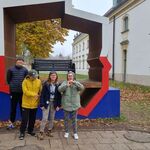 Czwórka uczniów na tle Ławki z konturem Polski przy Pałacu Branickich.