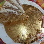 Na kraciastej serwetce stoi talerz z ciastem. obok leżą świeczki w kształcie 1 i 8.