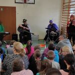 Czteroosobowy zespół muzyczny - od lewej instrument klawiszowy, gitara, śpiew, akordeon. Artyści przebrani w stroje owadów.