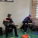 Czteroosobowy zespół muzyczny - od lewej instrument klawiszowy, gitara, śpiew, akordeon. Artyści przebrani w stroje owadów.