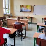 Na zdjęciu widać całą klasę: 4 dziewczynki i chłopca którzy oglądają jesienna prezentację.