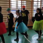 Grupa uczniów w tańcu. Z przodu dziewczyny w kolorowych tiulowych spódnicach.