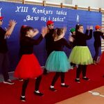 Grupa taneczna w kroku tanecznym na tle napisu XIII Konkurs tańca 